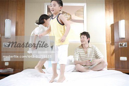 Father playing with son and daughter