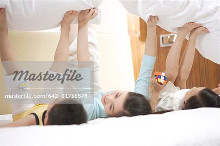 Mother and children playing with pillow