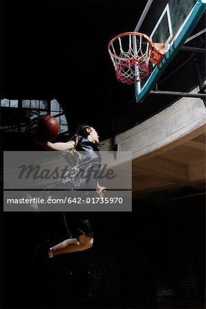 Young man jumping and dunking