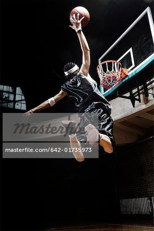 Slam de joueur de basket-ball tremper un ballon de basket