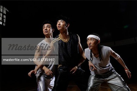 Trois basketteur jouant au basketball