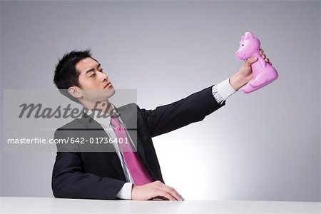 Young businessman holding toy