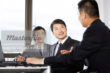 Businessmen people discussing in an office, smiling