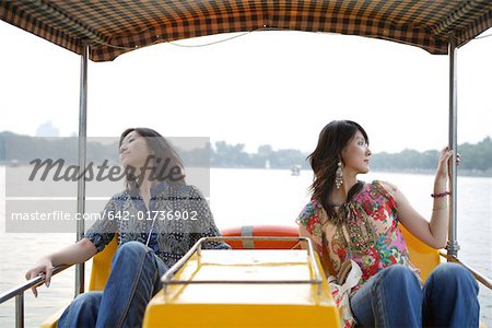 Two young women sitting on boat