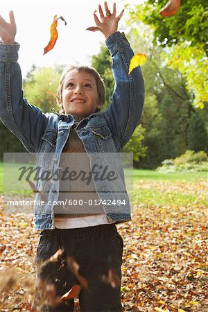 Boy Throwing Leaves in Air