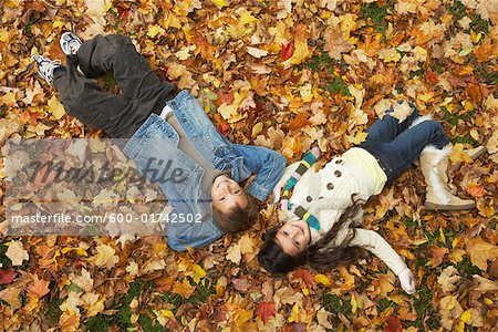 Enfants se trouvant dans les feuilles d'automne