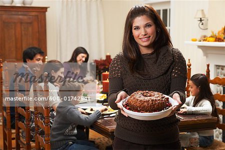 Frau hält Dessert bei Familie Abendessen
