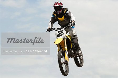 Low Angle View ein Motocross-Fahrer einen Sprung auf einem Motorrad durchführen