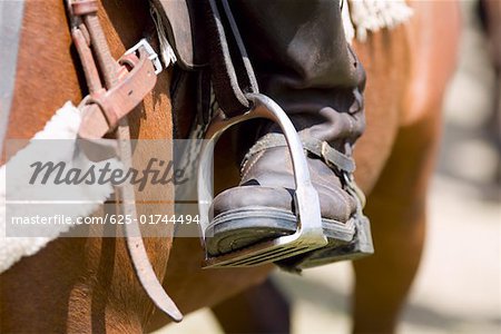 Close-up of a person's leg in a stirrup