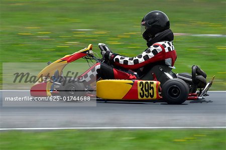 Profil de côté d'une personne go - Karting sur une piste de course automobile