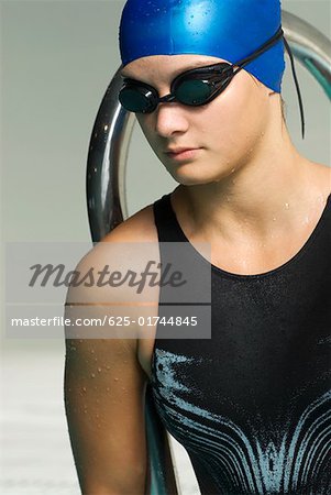 Close-up of a teenage girl wearing a swimming cap and swimming goggles