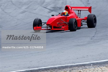 Person driving a formula one racing car on a motor racing track