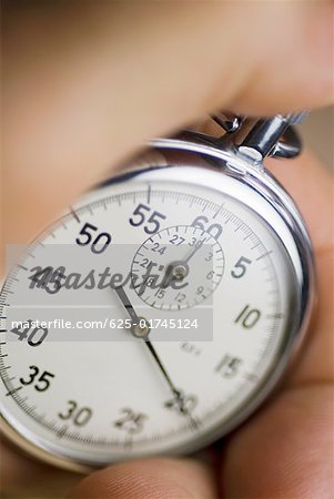 Close-up of a person's hand holding a stopwatch
