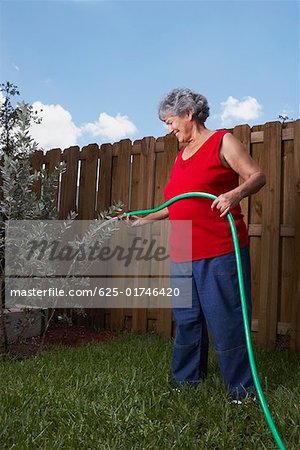 Side profile of a senior woman watering a plant