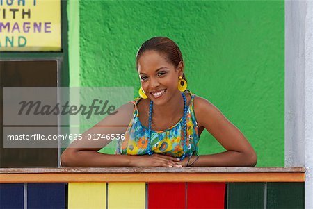 Portrait of a young woman leaning on a railing and smiling