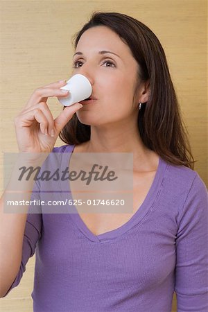 Close-up of a mid adult woman sipping from a mouthwash cup