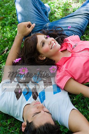 High angle view of a young couple lying in a park