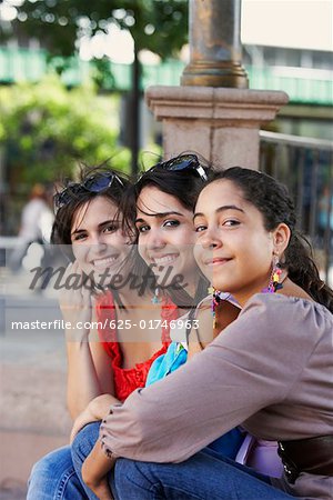 Side profile of three young women sitting together and smiling, Old San Juan, San Juan, Puerto Rico