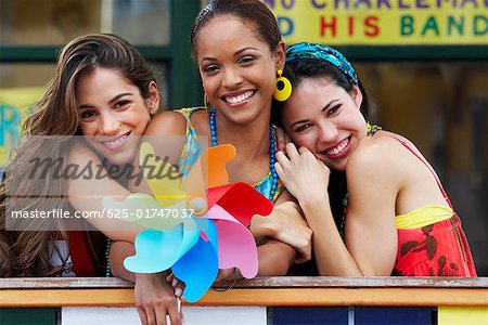 Portrait of three young women smiling and holding a pinwheel