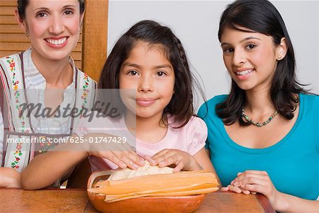 Portrait d'une jeune fille prépare le pain avec sa mère et sa soeur dans la cuisine