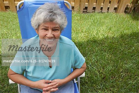 Portrait of a senior Woman in einem Liegestuhl sitzen und Lächeln