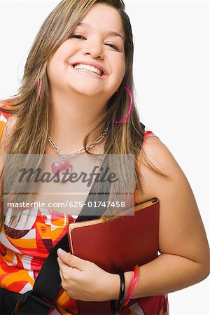 Portrait d'une jeune femme tenant un journal et souriant