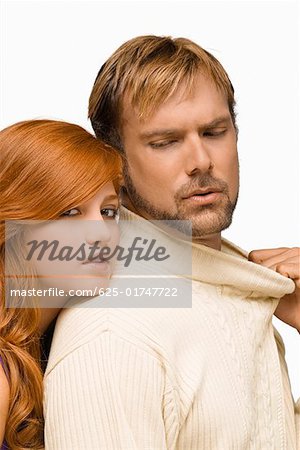 Portrait of a young woman resting her face on the shoulder of a mid adult man