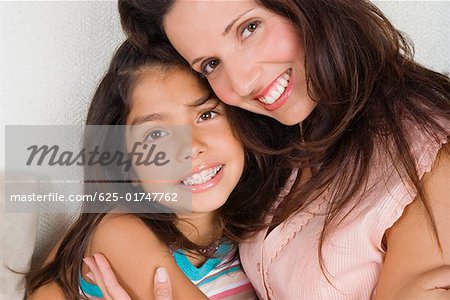 Portrait of a mid adult woman hugging her daughter