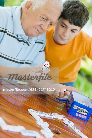 Senior homme jouer au domino avec son petit-fils