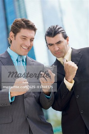 Two businessmen looking at a hand held device