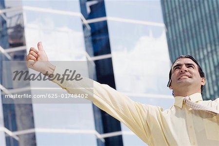 Businessman using a bluetooth device and making a thumbs up sign