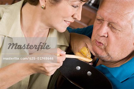 Close-up of a senior woman feeding a senior man