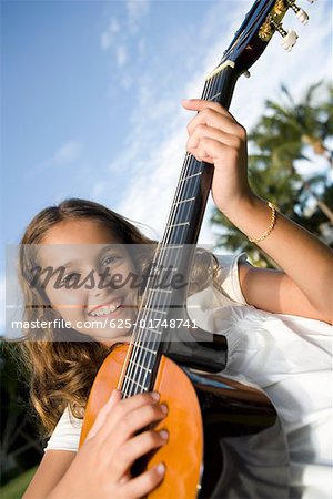 Portrait d'une jeune fille joue une guitare