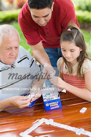 Senior homme jouer au domino avec sa petite fille et son fils