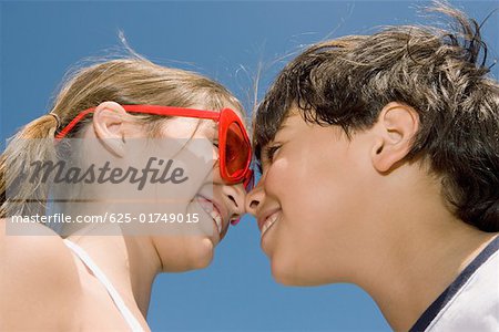 Low angle view of a girl and her brother looking at each other and smiling