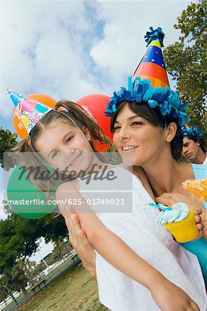 Close-up of a girl standing with her mother and smiling