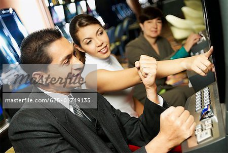 Seitenansicht eines Reifen Mannes auf eine Slot Maschine mit ein junges Mädchen neben ihm spielen