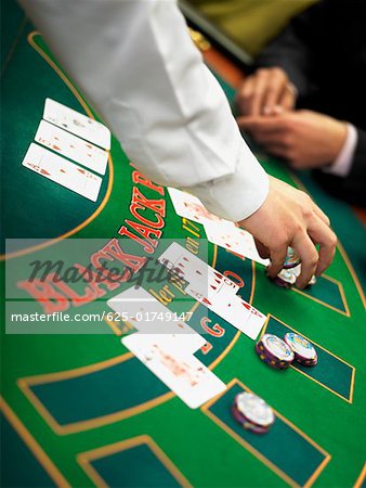 Casino worker's hand placing gambling chips on a gambling table