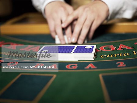 Close-up of a casino worker's hand shuffling playing cards on a gambling table