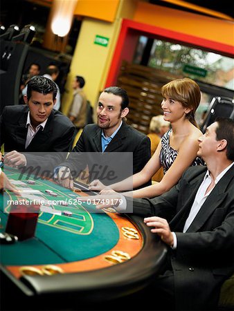 Four people playing blackjack in a casino