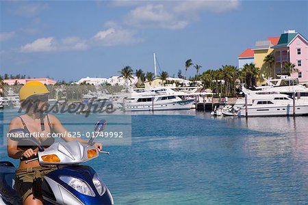 Mid adult woman driving a moped, Paradise Island, Bahamas