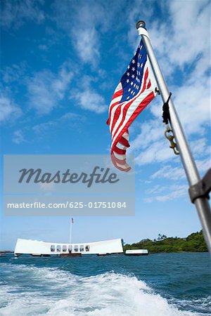 American flag fluttering with a memorial building in the background, Pearl Harbor, Honolulu, Oahu, Hawaii Islands,