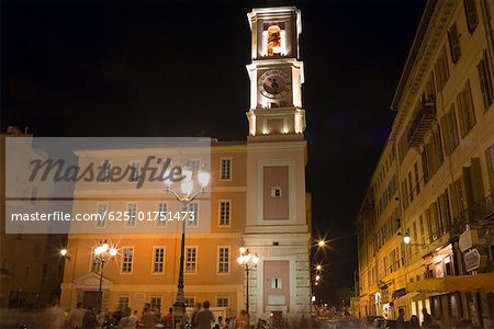 Vue d'angle faible d'une tour horloge éclairée la nuit, Nice, France