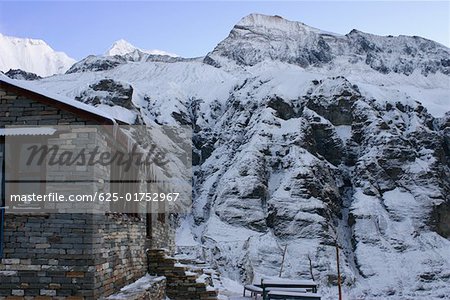 House in front of a snow covered mountain, Annapurna Range, Himalayas, Nepal