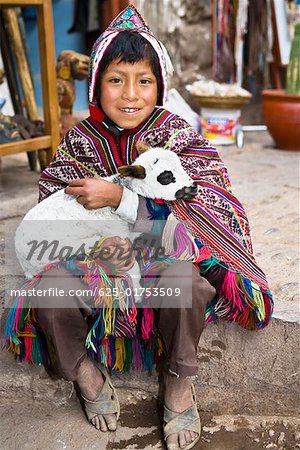 Portrait d'un garçon tenant un agneau et souriant, Pisaq, vallée de l'Urubamba, Pérou