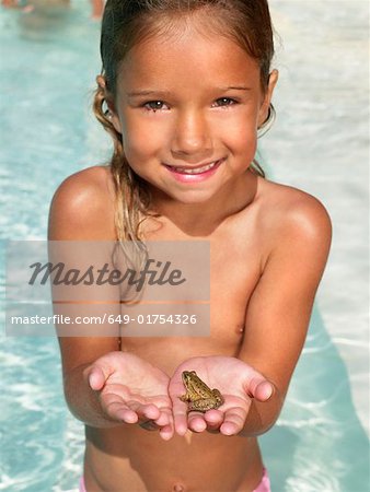 Petite fille tenant une grenouille.