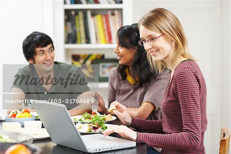 Femme utilisant un ordinateur portable à la Table du dîner