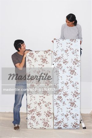 Couple Putting Up Wallpaper