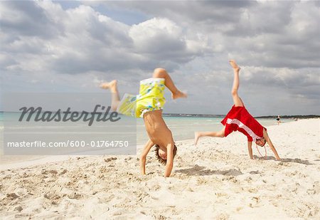 Boy and Girl doing Cartwheels on Beach, Majorca, Spain