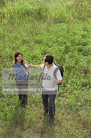 Man and woman hiking outdoors, nature, holding hands